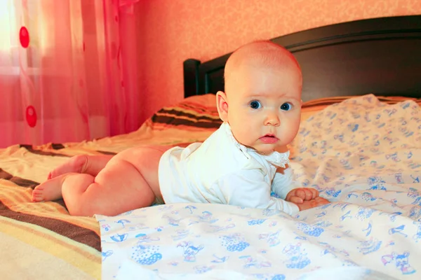 Bebé recién nacido está acostado en la cama. Niño buscando —  Fotos de Stock