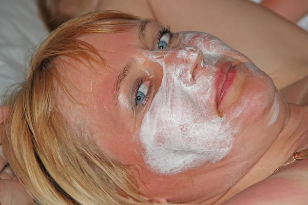 Menina bonita com creme facial. Mulher de 40 anos cuidando do rosto — Fotografia de Stock