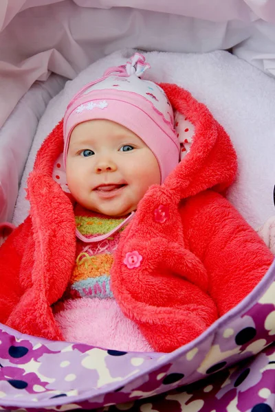 Liten baby smiler i barnevogn under en spasertur – stockfoto