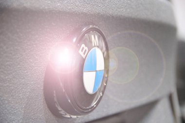 Gri arka planda yanıp sönen ışınlı BMW araba simgesi. Araba imalatçısı Bmw