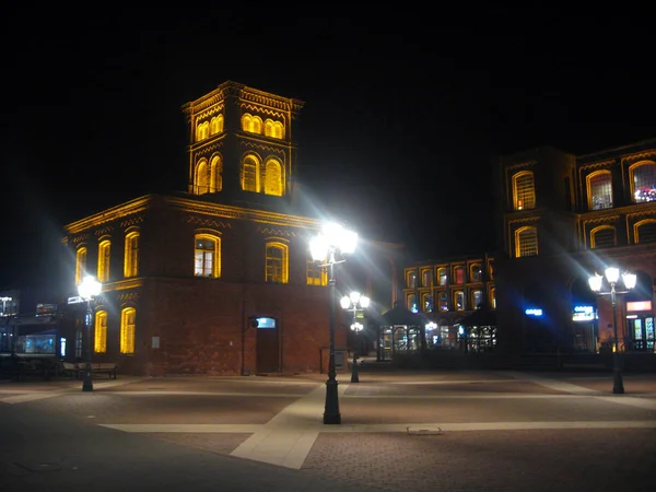 Hermosa iluminación de viejos edificios de ladrillo rojo por la noche en Lodz — Foto de Stock