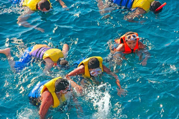 Pessoas mergulhando no mar com máscaras e coletes salva-vidas — Fotografia de Stock