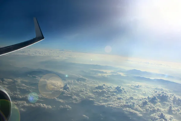 Bulutlar üzerinde sabah güneşinde uçağın penceresinden güzel görünümü — Stok fotoğraf