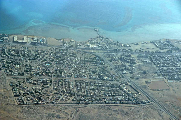 Luchtfoto uitzicht op de stad met huizen, gebouwen, aan zee in Egypte. Vliegen boven het land — Stockfoto