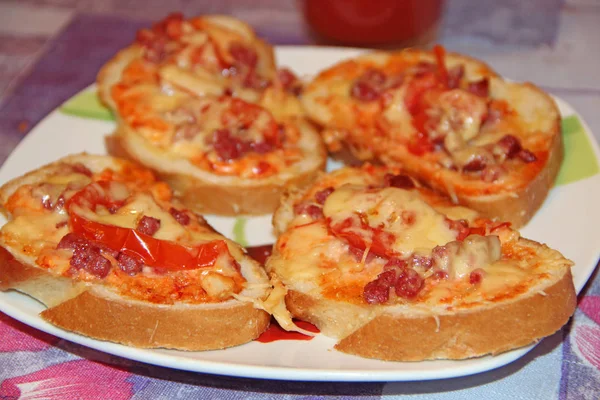 Горячие сэндвичи с колбасой и расплавленным сыром на тарелке — стоковое фото