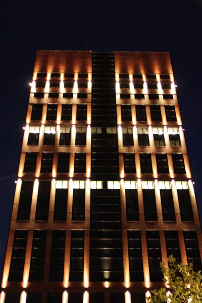 Piękne oświetlenie na nowoczesnym drapaczu chmur w nocnym mieście. oświetlony budynek — Zdjęcie stockowe