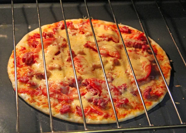 Köchin bereitet köstliche Pizza im Ofen zu. Kochen von Fast Food im Restaurant — Stockfoto