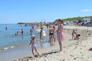 İnsanlar yaz tatili sırasında Baltık Denizi sahilinde dinlenmek