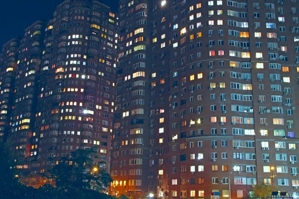Maisons éclairées à plusieurs étages dans la nuit. Panorama urbain — Photo