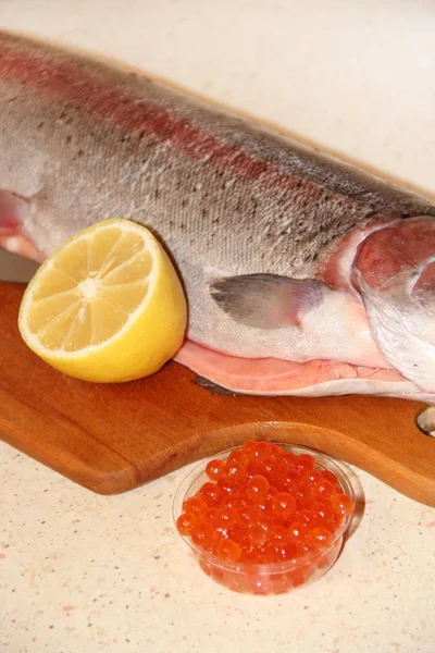 Peixe-truta arco-íris e caviar vermelho estão prontos para cozinhar com limão — Fotografia de Stock
