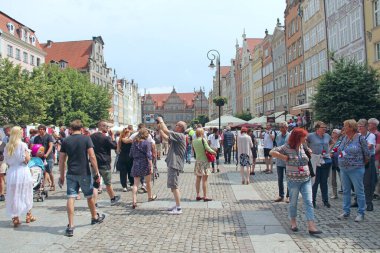 Turist kalabalığı Gdansk 'ın tarihi bölümünde yürüyor. Yolculuk sırasında Avrupalı turistler
