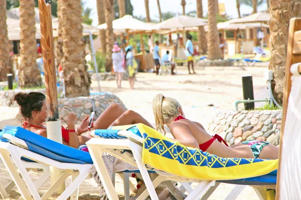 Mujeres Jóvenes Tumbadas Chaise Longue Sombra Bajo Paraguas Playa Disfrutando — Foto de Stock