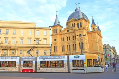 Lodz / Poland. 18 July 2019: Modern tram going on street of Lodz. Popular touristic attraction and destination. Colored tramway going along city. Modern passenger transportation