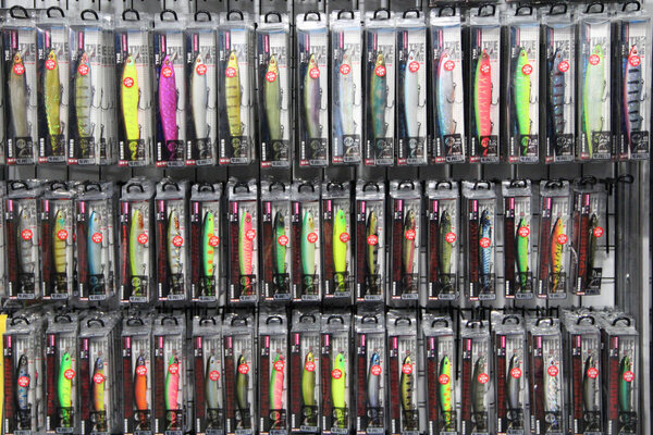 Kyiv / Ukraine. 09 March 2019: Colorful fishing lures on sale. Set of different plugs for fishing. Colorful fishing plugs on black background. Wide assortment of devices for fish hobby in shop