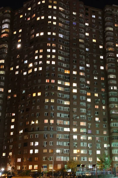 夜は多階建ての家がライトアップされます 都市のパノラマ 夜の大都市のカラフルな照明 高層ビルが多い 複数階建ての建物の窓の光の夜のパノラマ 大都市での生活 — ストック写真