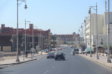Hurghada / Mısır. 02 Ağustos 2018: Hurghada 'daki binalarla ilgili sokak arabalı şehir panoraması. Otoyolda arabaları olan modern bir şehir. Hurghada 'da karayolu üzerinde ulaşım ve trafik. Mısır 'ın Hurghada şehrinde işlek cadde
