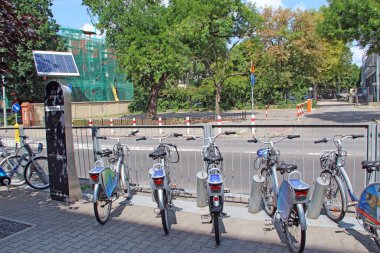 Varşova / Polonya. 27 Temmuz 2019: Birçok bisikletli şehir caddesi manzarası. Kiralık otoparkta park etmiş bisikletler. Şehirde kiralık bisikletler var. Varşova 'da bisiklet kiralama. Yeşil şehir taşımacılığı. Sokak ulaşımı