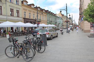 Lodz / Polonya. 18 Temmuz 2019: Birçok bisikletli şehir sokağı manzarası. Kiralık otoparkta park etmiş bisikletler. Şehirde kiralık bisikletler var. Lodz 'da bisiklet kiralama. Yeşil şehir taşımacılığı. Sokak ulaşımı