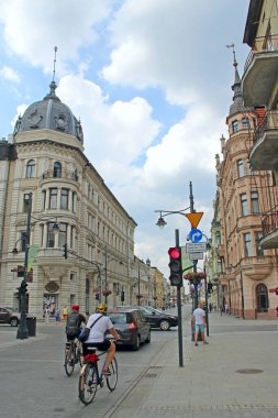 Lodz / Poland. 18 July 2019: Central street of Lodz decorated with Polish flags. Young woman walking along city street. View of main street of Lodz. Central street of Lodz Piotrkowska in the afternoon