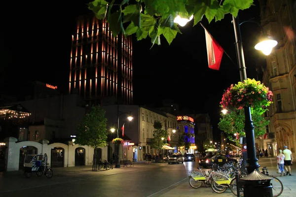 Lodz ポーランド 2019年7月18日 自転車で夜の街 夜間の市内自転車レンタル 都市交通 夜の超高層ビルの照明 レンタル用の自転車 市内の自転車レンタル 自転車通りの夕景 — ストック写真
