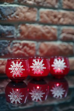 Beyaz kar taneleri ile üç mum.