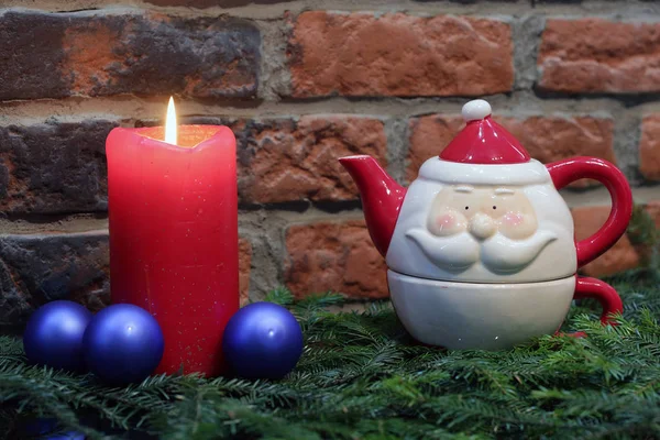 Rode kaars, blauwe kerstballen en Santa Claus theepot — Stockfoto