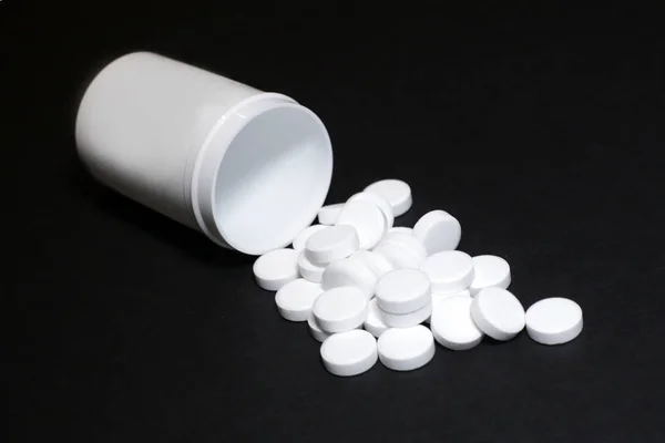 Pillole bianche, medicinali, su sfondo blach — Foto Stock