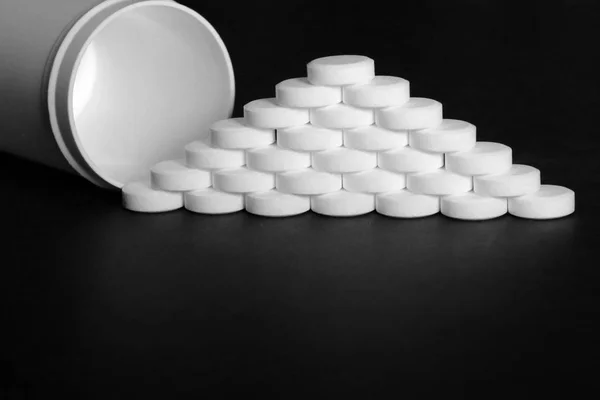 White pills, medicines, on a blach background — Stock Photo, Image
