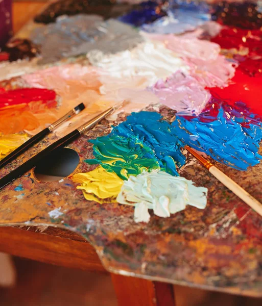 Kunstenaar palet met verf penselen — Stockfoto