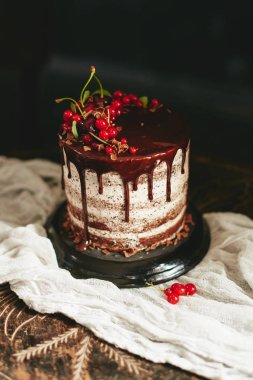 Eski ahşap masa üzerinde kırmızı meyveler üzümü ile çikolatalı kek