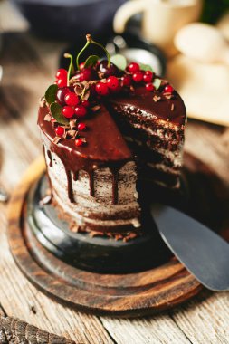 Eski ahşap masa üzerinde kırmızı meyveler üzümü ile çikolatalı kek