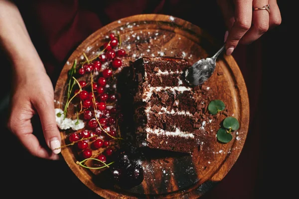 Женщина ест шоколадный торт с ягодами красной смородины — стоковое фото