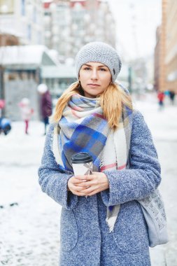 Kız gri ceket, şapka ve battaniye eşarp kış Caddesi üzerinde kahve ile