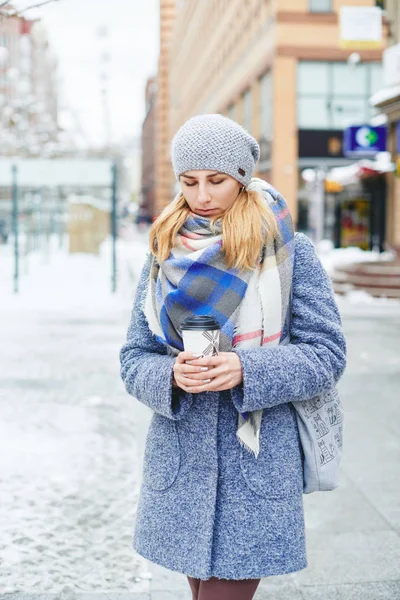 Menina de casaco cinza, chapéu e lenço com xícara de café na rua de inverno — Fotografia de Stock