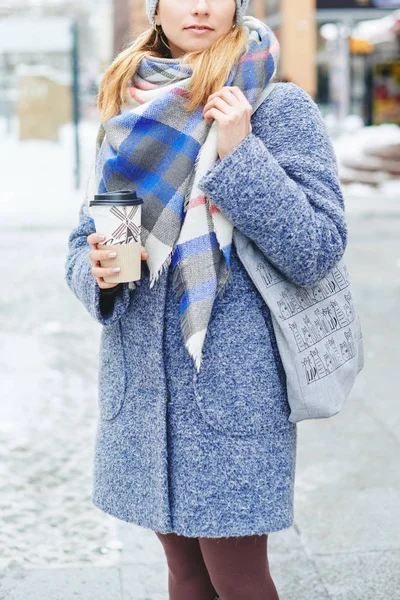 Menina de casaco cinza, chapéu e lenço com xícara de café na rua de inverno — Fotografia de Stock