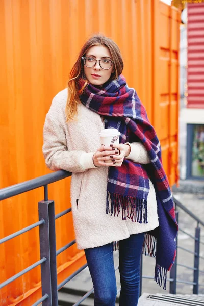 Chica en gafas y manta bufanda con célula escocesa — Foto de Stock