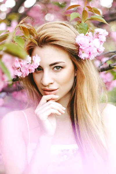 Portrait of beautiful girl on cherry blossom background — Stock Photo, Image