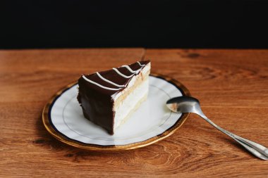 Sufle pasta tatlı plaka ahşap masa siyah arka plan üzerine dilimlenmiş