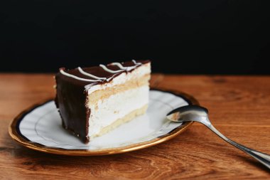 Sufle pasta tatlı plaka ahşap masa siyah arka plan üzerine dilimlenmiş