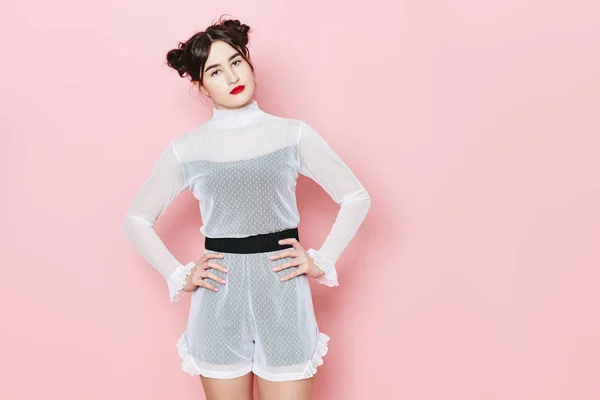 Mode foto van jong meisje die zich voordeed op roze achtergrond in de studio — Stockfoto