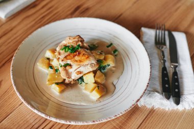 Kızarmış tavuk ve patates ahşap masa üzerinde plaka yakın çekim