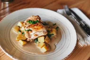 Kızarmış tavuk ve patates ahşap masa üzerinde plaka yakın çekim