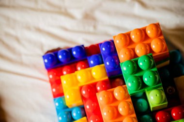 Bir sürü renkli gökkuşağı oyuncağı tuğla arka planda. Beyaz arka planda izole edilmiş çocuklar için eğitici bir oyuncak. Kopyalama alanı olan üst görünüm