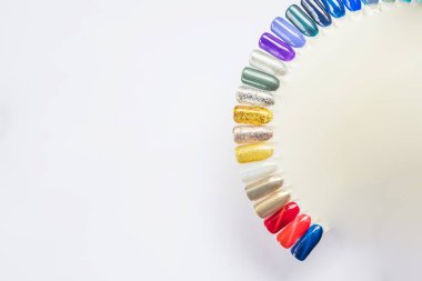 Çok renkli manikür, beyaz arka planda izole edilmiş manikürlü güzel kadın parmaklar. Çivi tasarım çarkı. Takma tırnaklar. Tırnak boyası için vernik renk paleti. Yapay