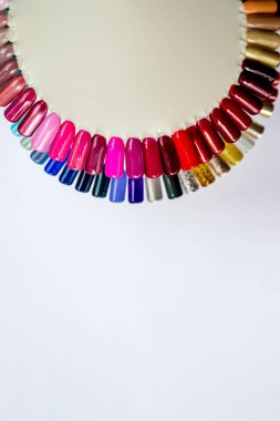 Çok renkli manikür, beyaz arka planda izole edilmiş manikürlü güzel kadın parmaklar. Çivi tasarım çarkı. Takma tırnaklar. Tırnak boyası için vernik renk paleti. Yapay