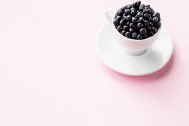 Beyaz bardakta yabanmersini. Sulu ve taze yaban mersinli çanak çömlek. Uzayı kopyala. Pembe arka planda taze böğürtlenli bardak. Taze meyve topluyorum.