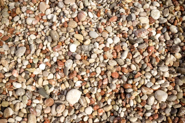 Kiezelsteen achtergrond.Kleine kleurrijke kiezelstenen achtergrond, eenvoud, daglicht, stenen.Glad watergedragen kiezelstrand gebruik voor tuin decoratie.Ontspannen op het strand.abstracte achtergrond met ronde kiezelsteen — Stockfoto