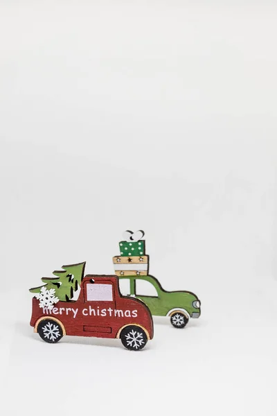 Świąteczne dekoracje drewnianymi samochodami, prezenty z przestrzenią do kopiowania. Kartka okolicznościowa, zaproszenie na przyjęcie, koncepcja świąt. Winter holidays.Toy samochód niosący choinkę. — Zdjęcie stockowe