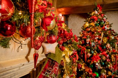 Süslü şömine ve Noel süslerinin tonlu görüntüsü. Noel arkaplanı için uygun. Noel ve yeni yıl arkaplanı: şömine, süsler, çelenkler, hediyeler, mumlar. Bir sürü ışık parlıyor.