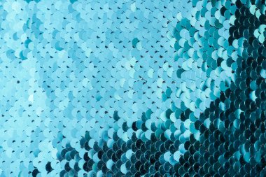 Makroyu yakınlaştırır. Kumaşın üzerinde mavi pullar olan soyut bir arkaplan. Yuvarlak pulların dokuları ve renk değişimi. Mavi renkli dairelerin arka planı. Soyut arkaplan deseni